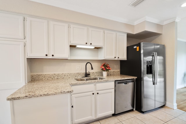 kitchen with appliances with stainless steel finishes, white cabinetry, sink, light tile floors, and ornamental molding