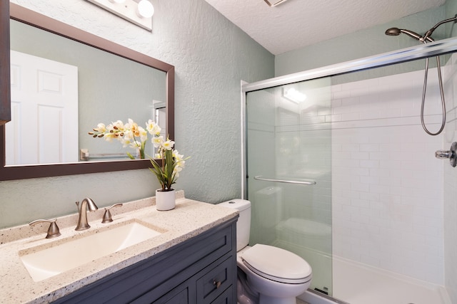 bathroom featuring vanity, an enclosed shower, toilet, and a textured ceiling