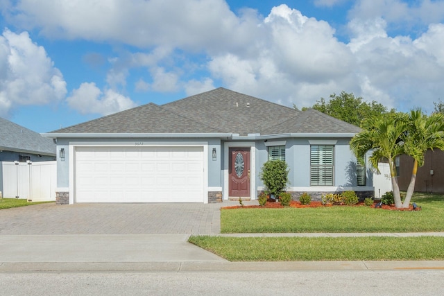 single story home with stucco siding, a front lawn, roof with shingles, and driveway