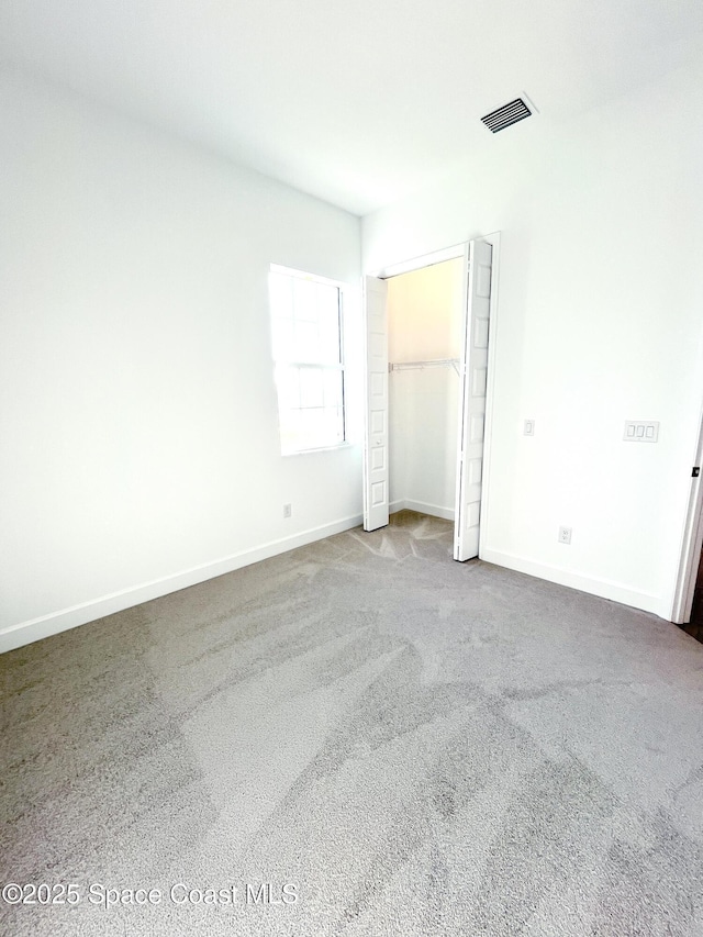 unfurnished bedroom featuring carpet floors, a closet, visible vents, and baseboards