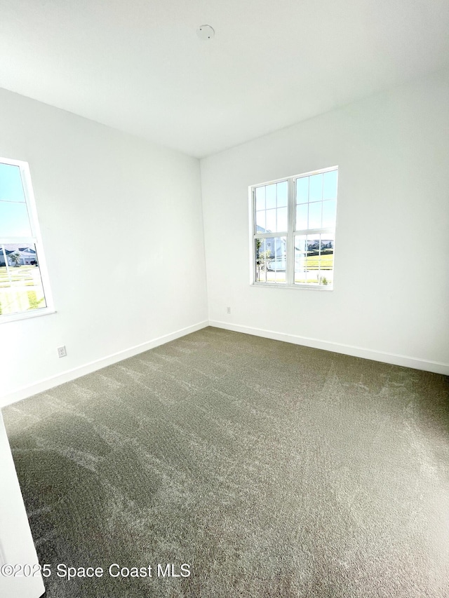 carpeted spare room with baseboards