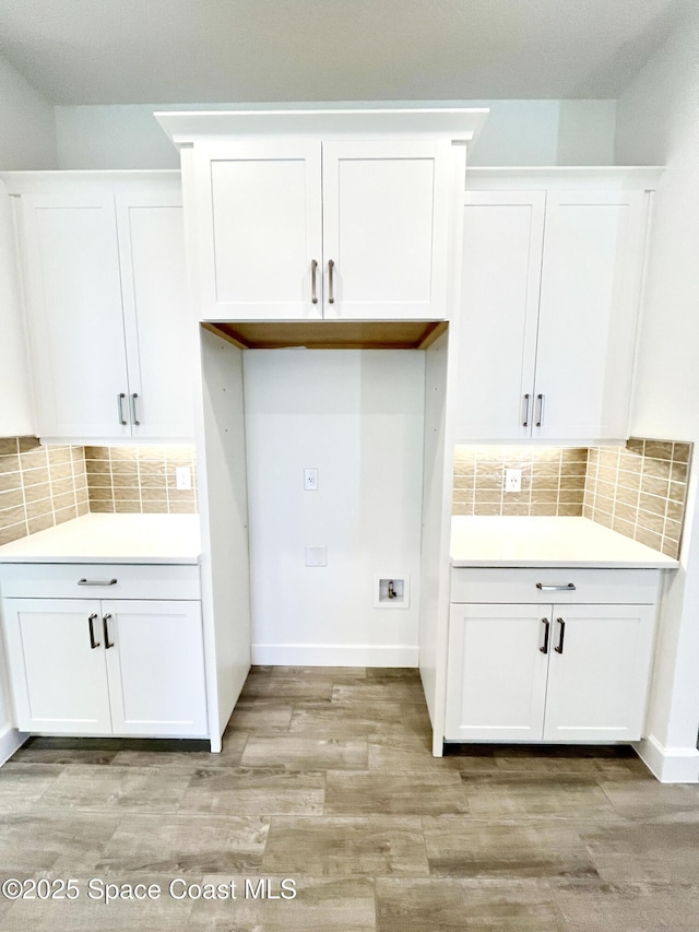 interior space featuring light wood finished floors, washer hookup, cabinet space, and baseboards