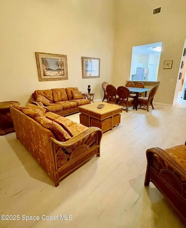 147 Aquarina, Melbourne Beach, FL 32951 - living room with a towering ceiling and baseboards