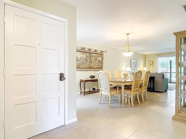 dining space with a textured ceiling and tile flooring