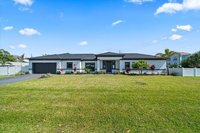 view of front of property with a garage and a front lawn