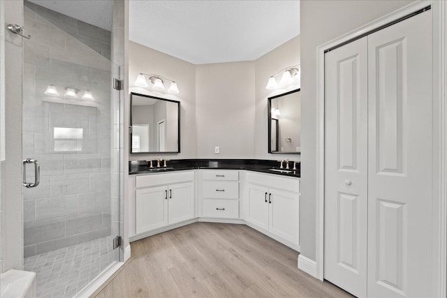 bathroom featuring wood-type flooring, vanity, and an enclosed shower