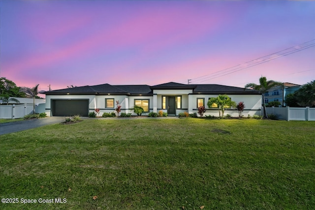 view of front facade with a garage and a lawn