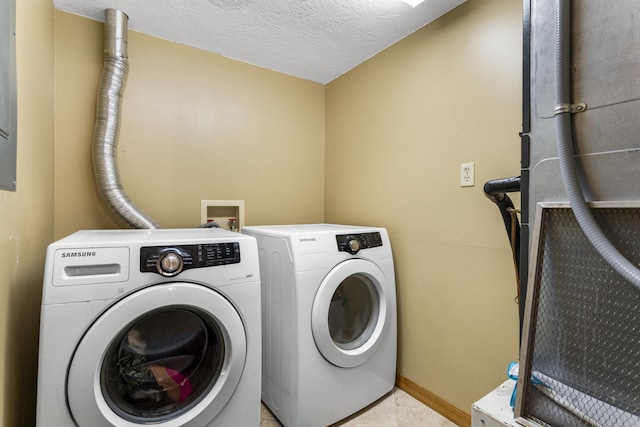 clothes washing area with washer and dryer and a textured ceiling