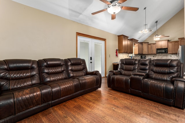 living room with dark hardwood / wood-style flooring, vaulted ceiling, french doors, and ceiling fan