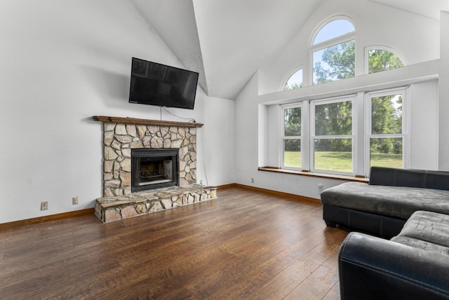 living room featuring hardwood / wood-style flooring, high vaulted ceiling, and a fireplace