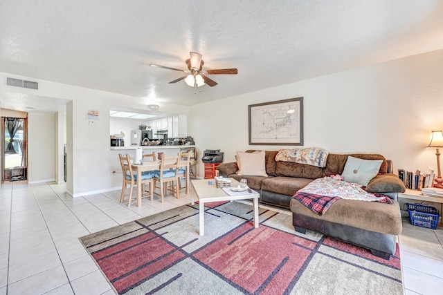 tiled living room with ceiling fan and a textured ceiling