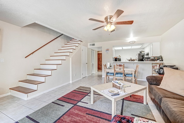 living room featuring light tile flooring and ceiling fan