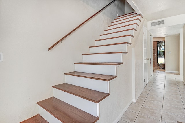 staircase with light tile floors