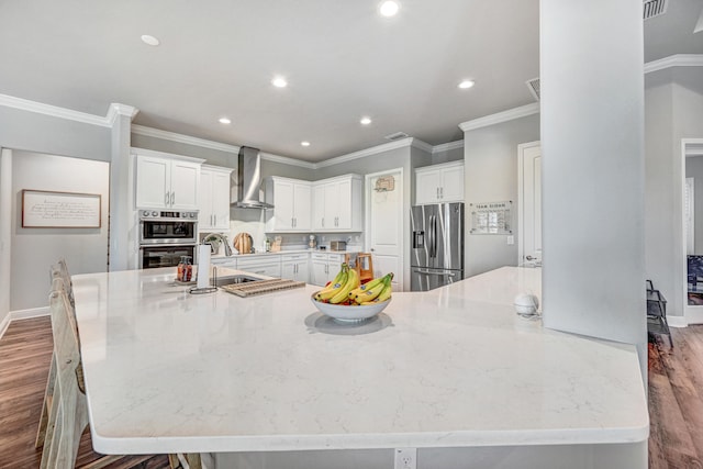 kitchen featuring white cabinetry, stainless steel appliances, dark hardwood / wood-style floors, and wall chimney exhaust hood