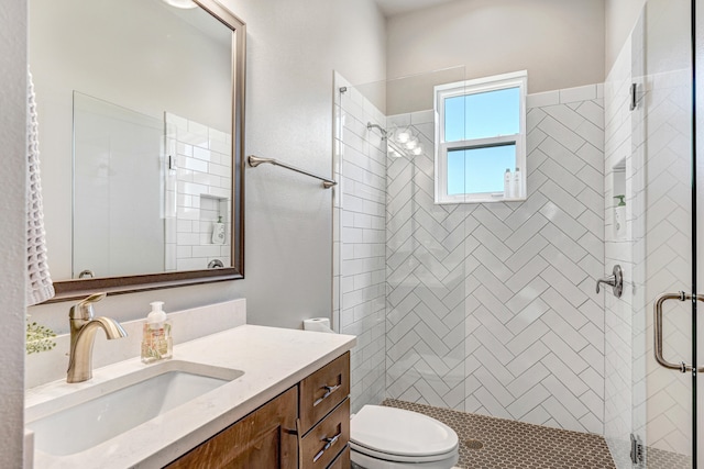 bathroom with a shower with shower door, toilet, and vanity