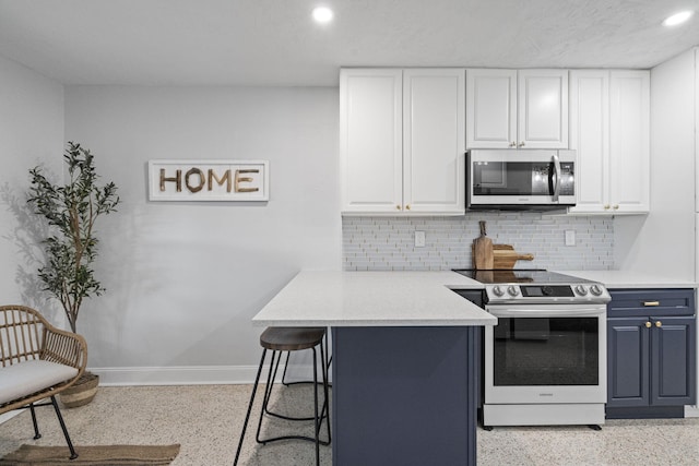 kitchen featuring electric range, a kitchen breakfast bar, white cabinetry, and blue cabinets