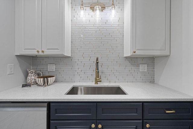 kitchen featuring dishwasher, tasteful backsplash, white cabinetry, and sink