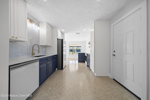 kitchen with white cabinetry, dishwasher, sink, blue cabinets, and stainless steel fridge