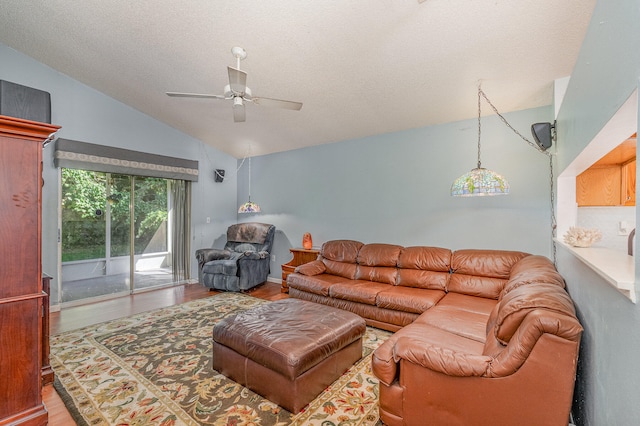 living room featuring hardwood / wood-style floors, ceiling fan, a textured ceiling, and lofted ceiling