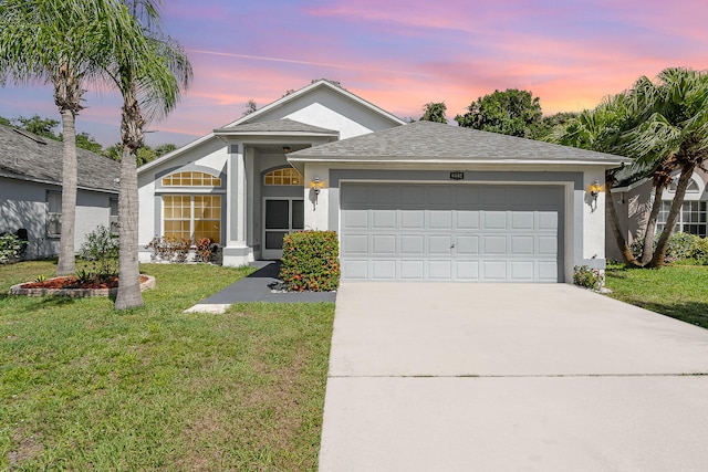 view of front facade featuring a garage and a yard