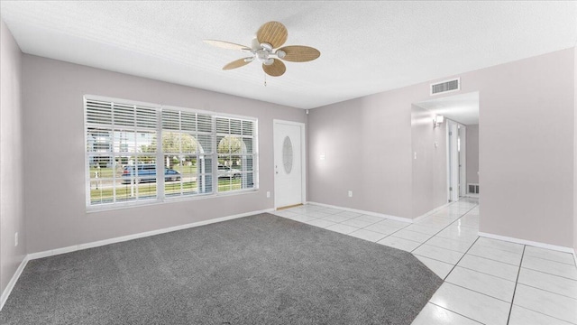 carpeted spare room featuring a textured ceiling and ceiling fan