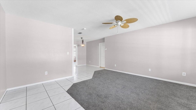 spare room with ceiling fan, light tile patterned flooring, and a textured ceiling