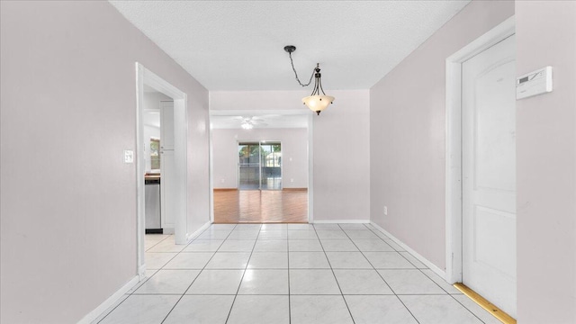 unfurnished dining area featuring a textured ceiling, ceiling fan, and light tile patterned flooring