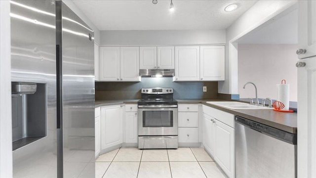 kitchen with sink, white cabinets, stainless steel appliances, and light tile patterned floors