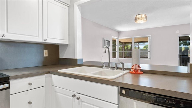 kitchen featuring a textured ceiling, a wall unit AC, sink, dishwasher, and white cabinetry