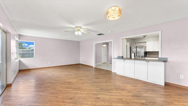 unfurnished living room with ceiling fan and light wood-type flooring