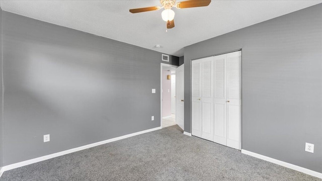 unfurnished bedroom featuring carpet, a closet, and ceiling fan