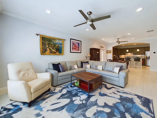 living room with ceiling fan and crown molding