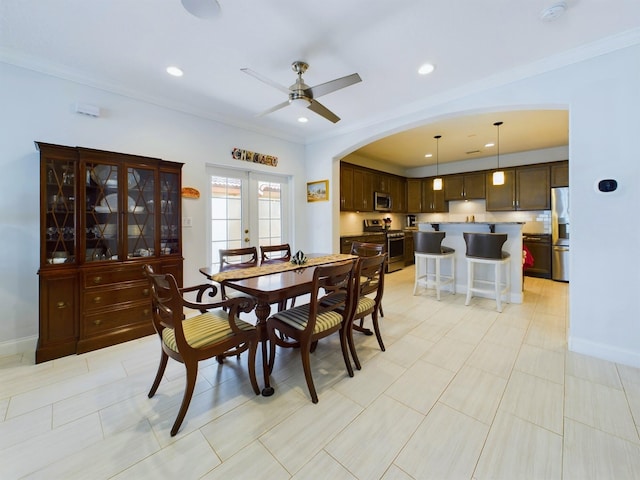 tiled dining area featuring ornamental molding, ceiling fan, and french doors