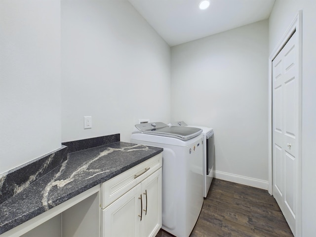 washroom with washer and dryer, cabinets, and dark wood-type flooring