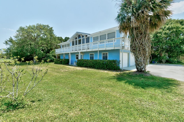 exterior space featuring a garage, a balcony, and a front lawn