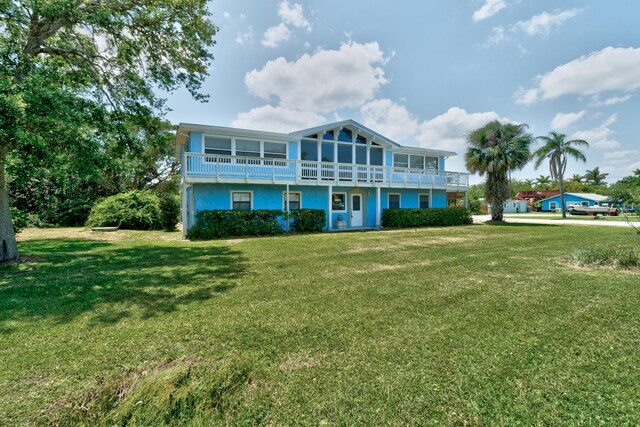 back of property featuring a yard and a balcony