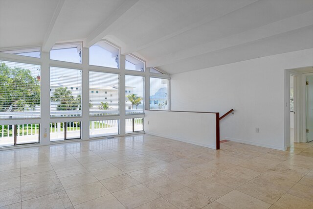 spare room featuring lofted ceiling with beams and light tile floors