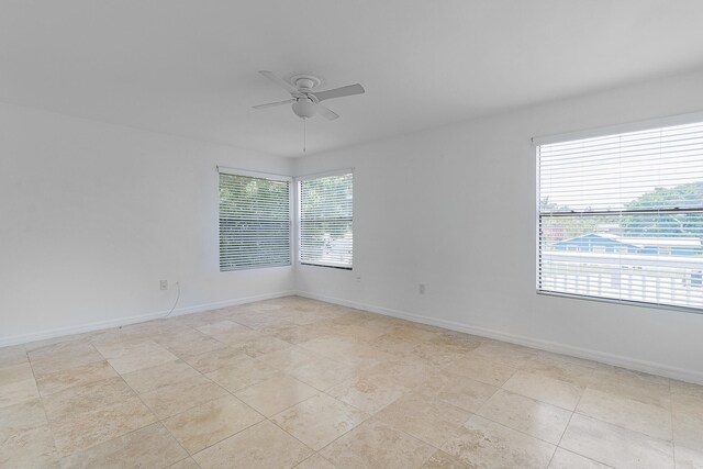 tiled spare room with ceiling fan