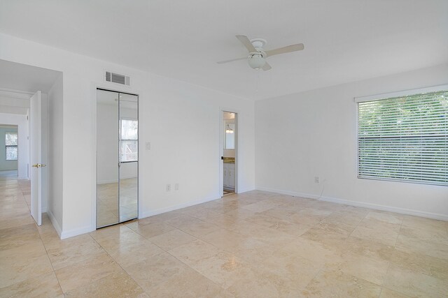 unfurnished bedroom with ceiling fan, multiple windows, and light tile floors