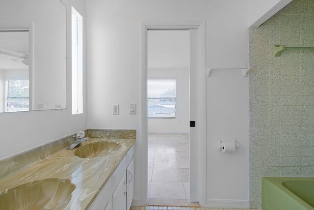 bathroom with a healthy amount of sunlight, vanity, and tile floors