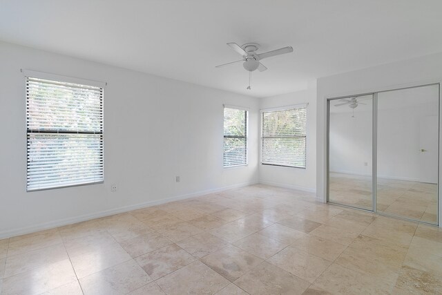 unfurnished bedroom featuring ceiling fan, a closet, and light tile flooring