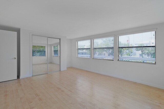 unfurnished room with a healthy amount of sunlight and light hardwood / wood-style flooring