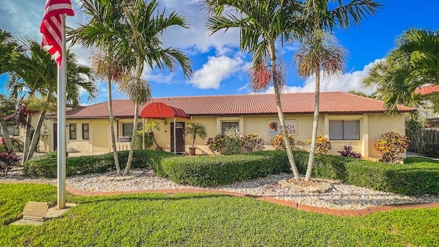 3173 Beach Winds Ct, Melbourne Beach, FL 32951 - ranch-style house featuring a tiled roof, stucco siding, and a front lawn
