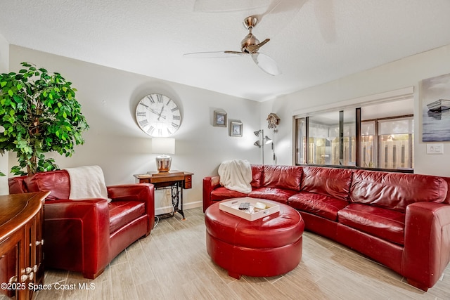 living room featuring ceiling fan, wood-type flooring, and a textured ceiling