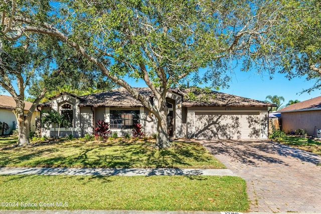 single story home featuring a front yard and a garage