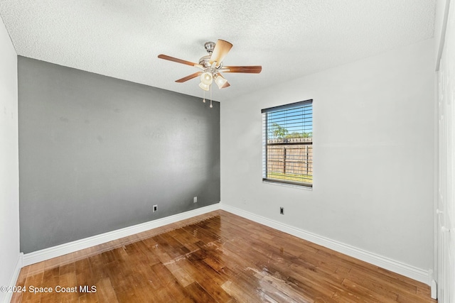 spare room with hardwood / wood-style floors, ceiling fan, and a textured ceiling