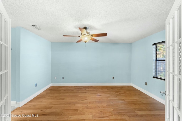 spare room with ceiling fan, french doors, a textured ceiling, and light hardwood / wood-style flooring