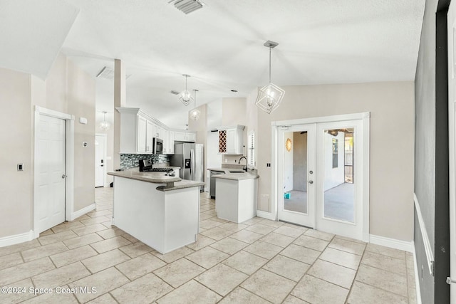 kitchen featuring kitchen peninsula, appliances with stainless steel finishes, french doors, decorative light fixtures, and white cabinetry