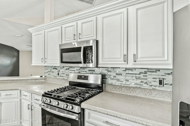 kitchen with decorative backsplash, white cabinetry, and appliances with stainless steel finishes