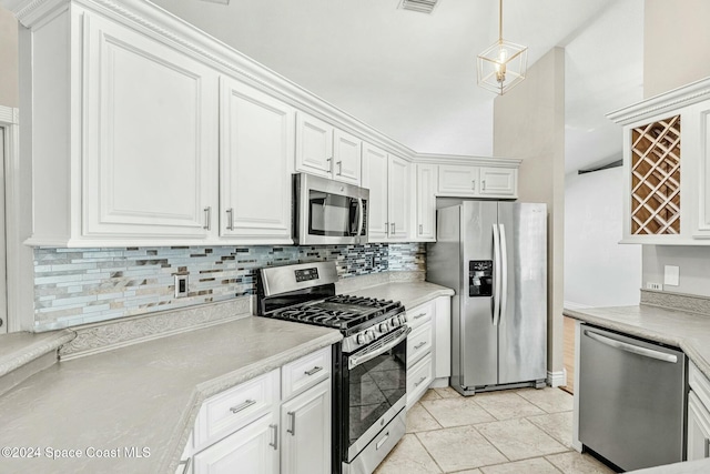 kitchen featuring white cabinets, appliances with stainless steel finishes, tasteful backsplash, and pendant lighting